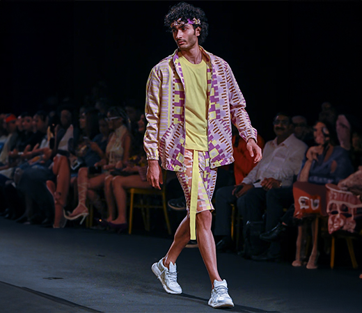 Model wearing a geometric printed denim bomber jacket for men by Nirmooha