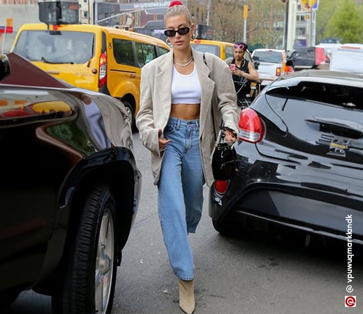 Hailey Bieber wears mom jeans with white crop top and an oversized blazer