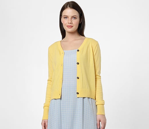 Woman wearing a yellow sweater over blue dress