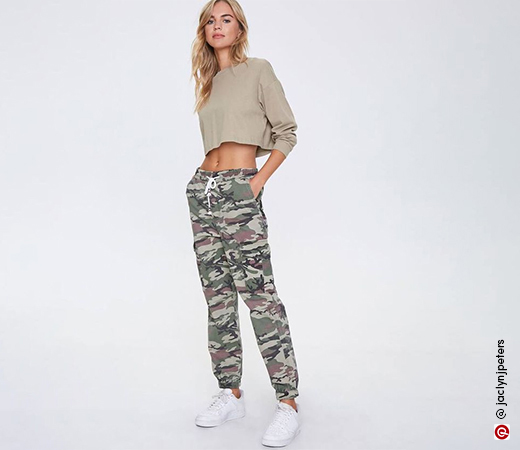 Woman wearing green crop top and camo print joggers