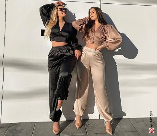 Women in black and beige satin joggers and crop tops