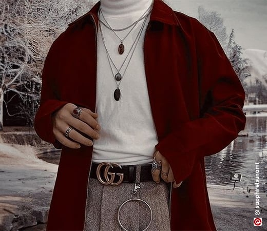 Man wearing maroon sweater with layered chains 