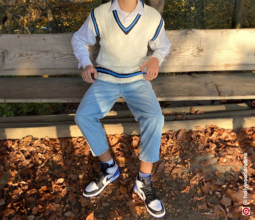 Man wearing a sweater vest with jeans