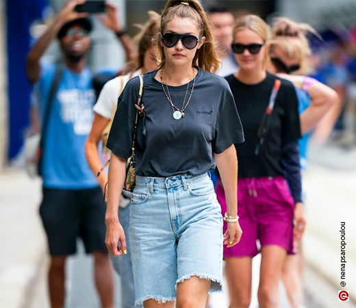 Gigi Hadid wearing black t-shirts with denim shorts