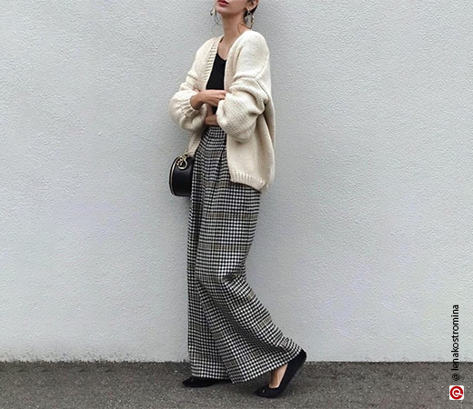 Woman wearing white cardigan with plaid trousers 