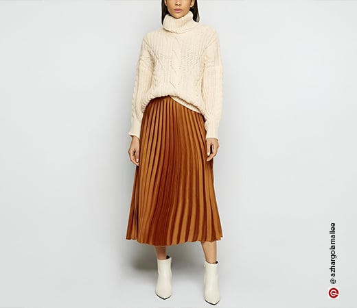 Woman wearing pleated skirt and knit sweater