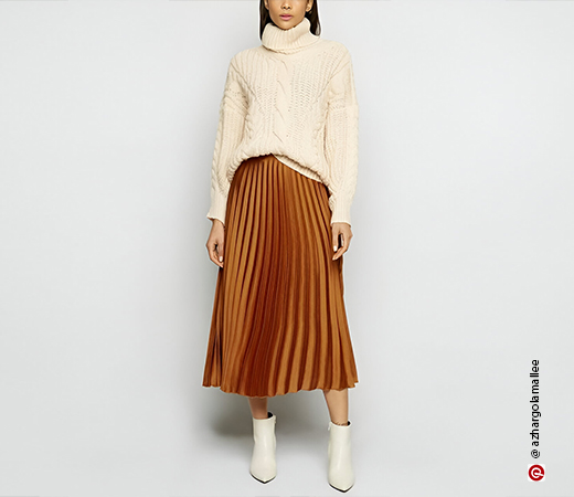 Woman wearing pleated skirt and knit sweater