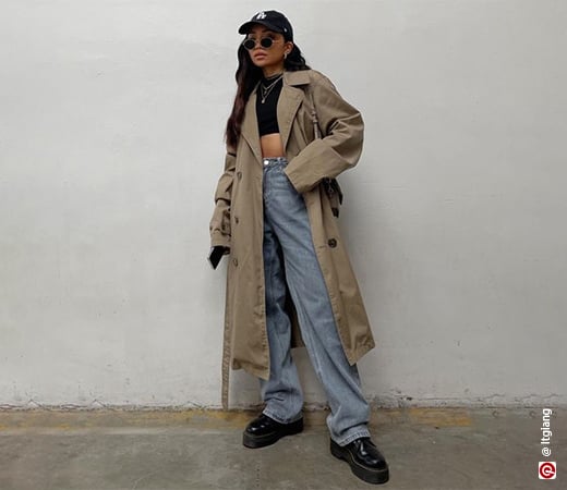 Woman wearing a trench coat and baggy jeans