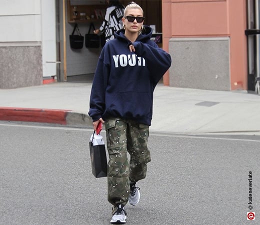Hailey Bieber in a slogan hoodie and cameo cargo pants