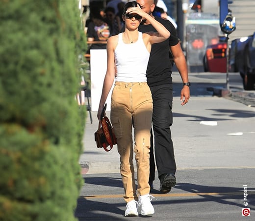 Kendall Jenner wearing a white tank top and beige cargo pants