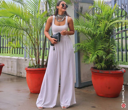 Woman wearing white crop top and pants with oxidised jewellery