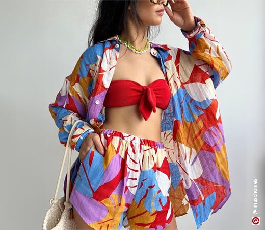 Model wearing a multi-coloured co-ord set with a red bralette