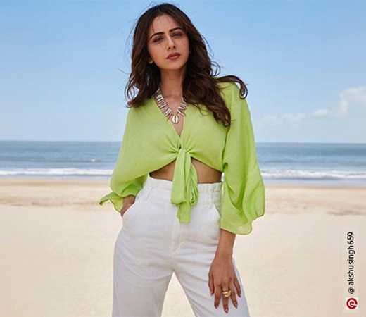 Rakul Preet wearing a green top with white trousers
