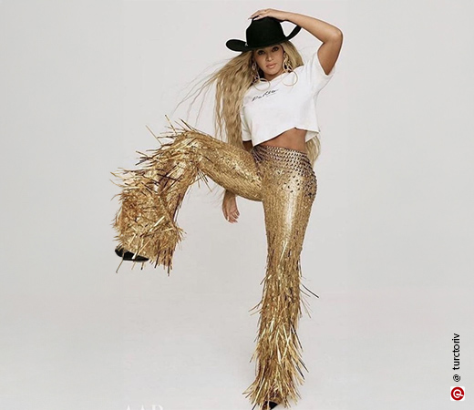 Beyoncé wearing golden pants and a white hat