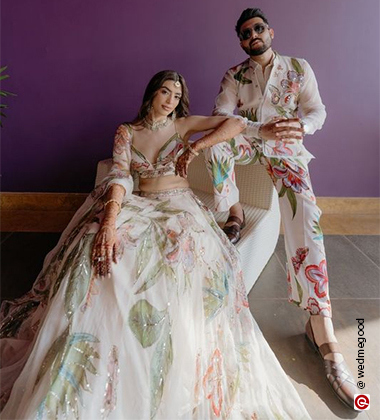 bride and groom sitting against a purple background
