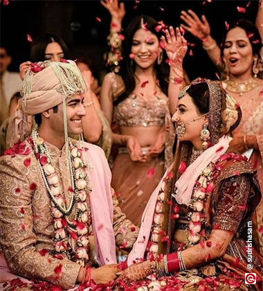 bride and groom sitting against the background of the wedding guests